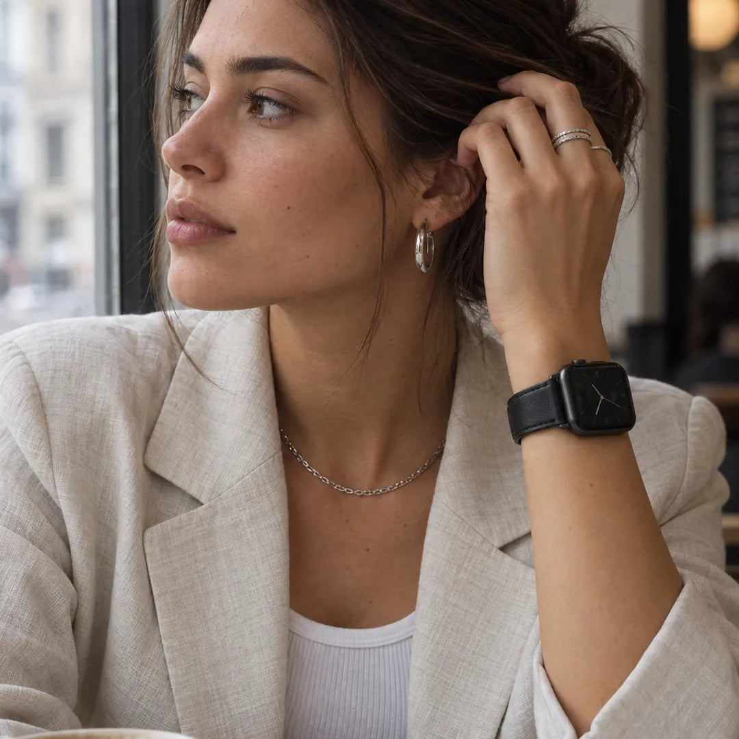 Frau im hellen Blazer trägt das Aura Leder Apple Watch Armband in Schwarz