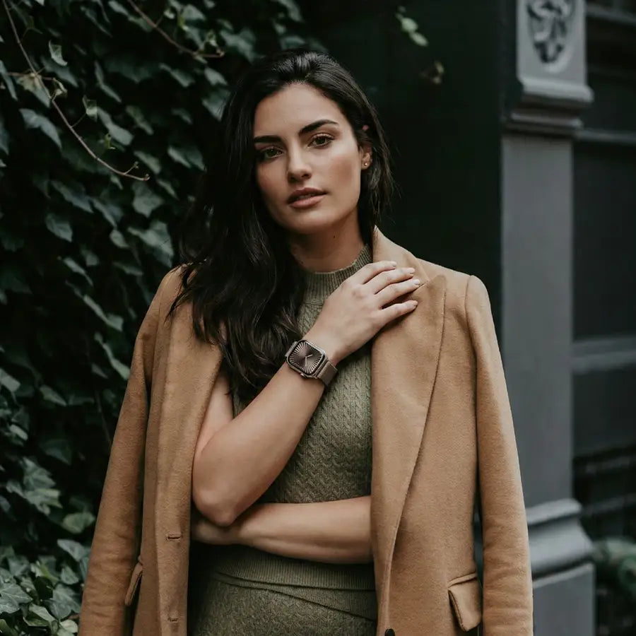 Frau mit elegantem Outfit trägt das Veloura Apple Watch Armband in Taupe – stilvolles Feingewebe-Armband mit magnetischem Verschluss, perfekt kombiniert für einen herbstlich-urbanen Look.